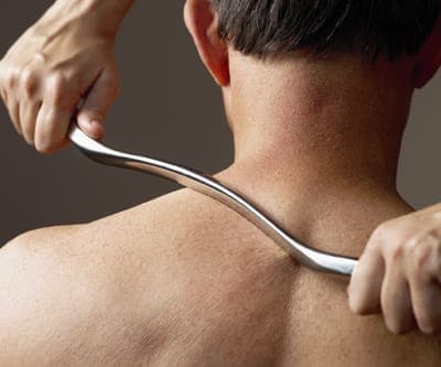 Instrument-assisted soft tissue mobilization (IASTM) treatment using specialized ergonomic tools