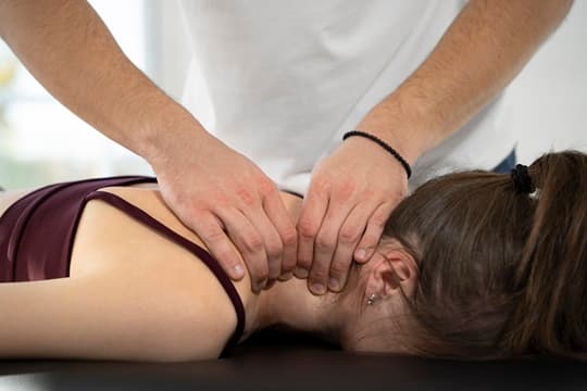 Physiotherapist performing myofascial release therapy on patient's back
