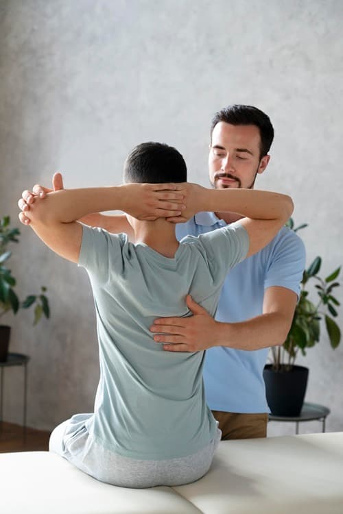 Physiotherapist examining a patient with back pain